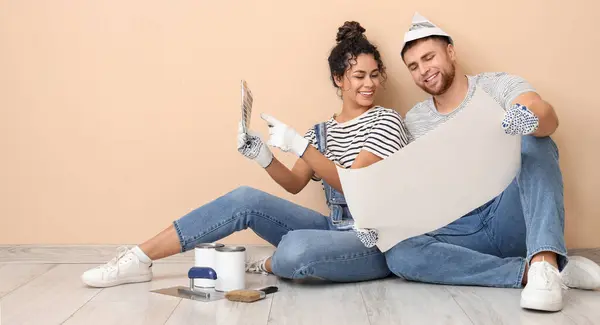 Happy young couple planning repair at home