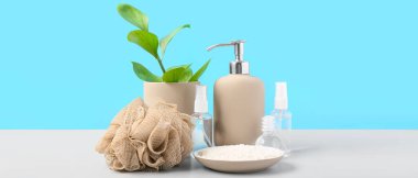 Masada mavi arka planda banyo süngeri ve kozmetik seti var. Tasarım için pankart