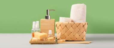 Banyo malzemeleri ve kozmetik seti yeşil arka planda.