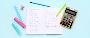 Açık mavi arkaplan üzerinde matematik formülleri, hesap makinesi ve kırtasiye ile metin kitabı