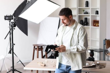 Stüdyoda profesyonel kamerası olan yakışıklı bir fotoğrafçı.