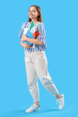 İtalya bayrağı ve açık mavi arkaplan üzerine kitapları olan genç bir kız öğrenci.