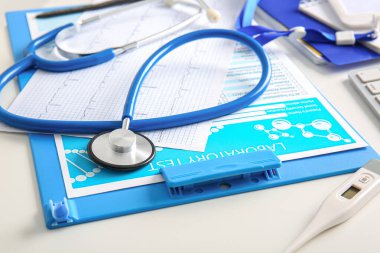 Beyaz sağlık masasında kardiyogram ve laboratuvar testli stetoskop, yakın plan.