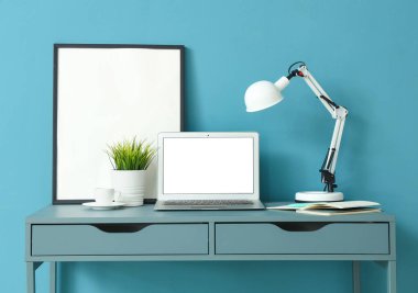 Boş dizüstü bilgisayarı ve yapay çimeni olan modern işyeri