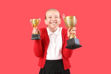 Kırmızı arka planda altın bardakları olan şirin bir kız.