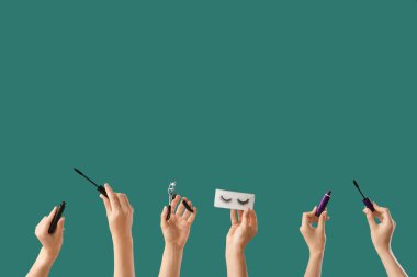 Yeşil arka planda takma kirpik, bigudi ve rimel olan kadınlar