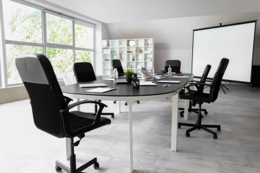 Masası ve raf ünitesi olan konferans odasının içinde.