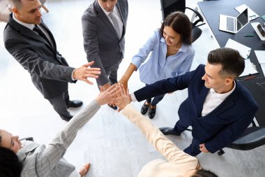 Bir grup iş adamı el ele tutuşuyor.