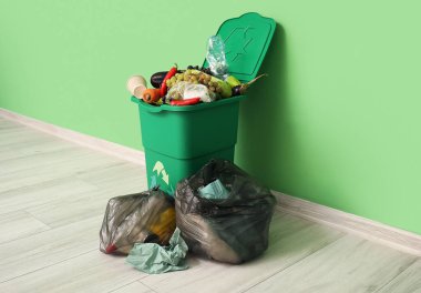 Yiyecek atıkları ve yeşil duvarın yanındaki çöp torbaları için konteynır. Geri dönüşüm kavramı