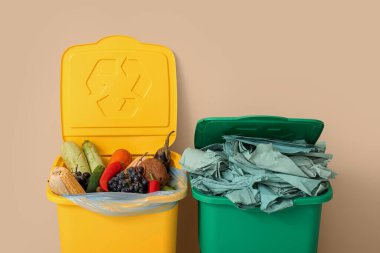 Bej duvarın yanında farklı çöp kutuları var. Geri dönüşüm kavramı