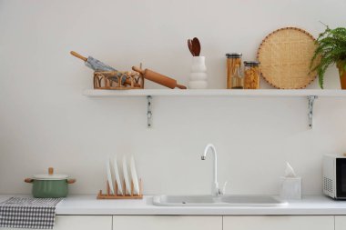 Modern mutfağın içinde çatal bıçak ve lavabo beyaz tezgahlarda.