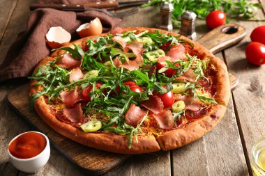 Tahta arka planda domatesli ve roka aromalı lezzetli pizzalar.