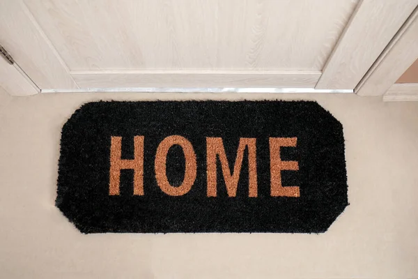 Doormat with word HOME in hall, top view