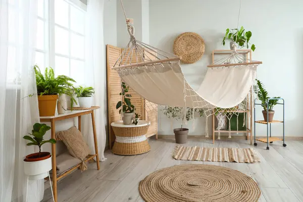 Interior of living room with green plants and hammock