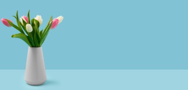 Mavi arka planda güzel pembe laleleri olan, metin için yeri olan bir vazo. Uluslararası Kadınlar Günü