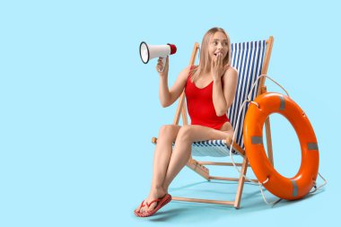 Megafonlu güzel bir kadın, güverte sandalyesi ve mavi arka planda yüzük şamandırası.