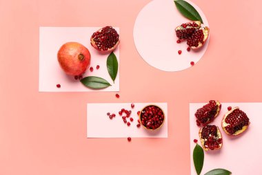 Taze nar ve renkli arkaplanda yaprakları olan bir kase tohum.