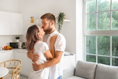 Mutlu çift mutfakta birbirine sarılıyor.