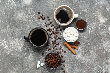 Gri arka planda tarçınlı ve şekerli bir fincan lezzetli kahve.