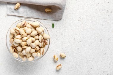 Beyaz arka planda fıstıklı cam kase.