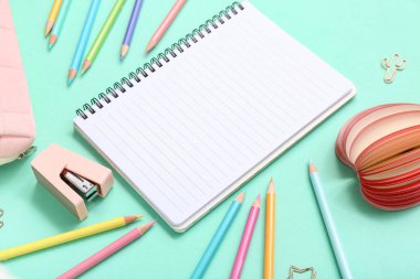 Turkuaz arka planda kırtasiye malzemesi olan bir sürü renkli kalem