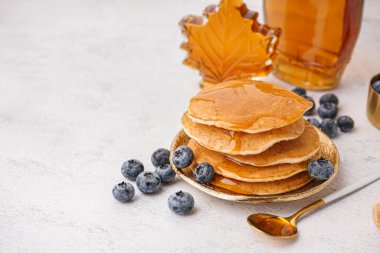 Beyaz arka planda yaban mersinli ve akçaağaç şuruplu lezzetli krepler.