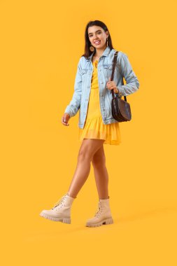 Sarı arka planda güzel, şık bir kadın.