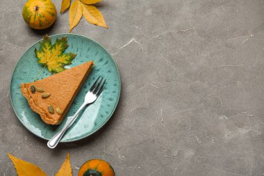 Gri arkaplanda lezzetli balkabağı turtası olan tabak.