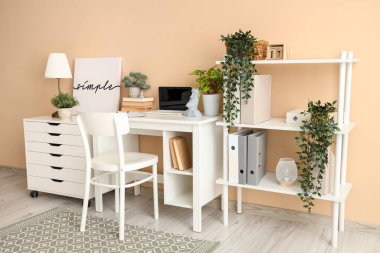 Çalışma yeri, raf ünitesi ve çekmeceleri olan şık bir ofis.