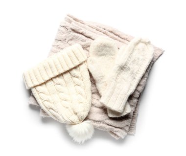Bir çift örgü eldiven, beyaz arka planda eşarp ve sıcak şapka.