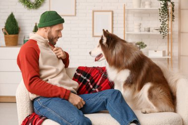 Evde sevimli köpekli yakışıklı bir genç adam.