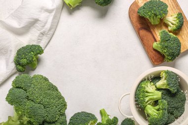 Taze yeşil brokoliden yapılmış çerçeve ahşap tahtadan ve beyaz grunge arka planda kevgir.