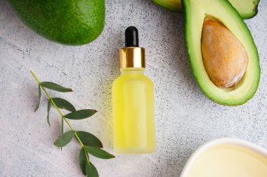 Taze avokado ve yağlı şişe grunge beyaz arka planda