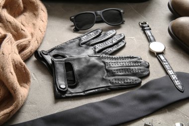 Deri erkek eldivenli kompozisyon ve grunge arka planda şık aksesuarlar.