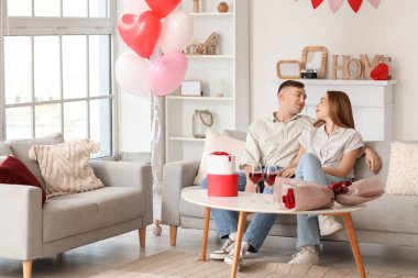 Güzel, genç ve mutlu bir çift sevgililer gününü evde kutluyor.
