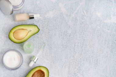 Taze avokado, krema ve arka planda gerekli yağ şişeleri