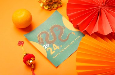 Kağıt vantilatörlü tebrik kartı, turuncu arka planda mandalina ve dekor. Çin Yeni Yıl Kutlaması