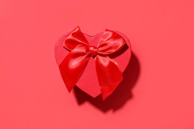 Kırmızı arka planda güzel bir hediye kutusu. Sevgililer Günü kutlaması