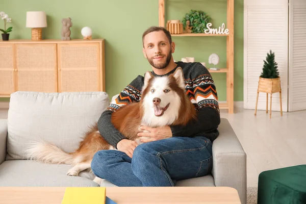 Evde sevimli köpekli yakışıklı bir genç adam.