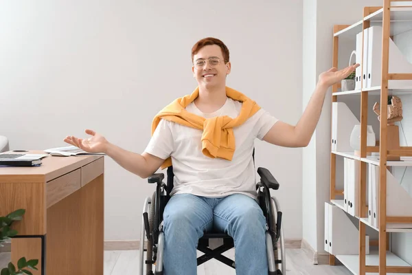 Portrait of young man in wheelchair at office