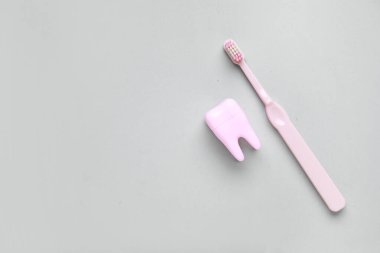 Beyaz arka planda elektrikli diş fırçası olan bir diş modeli. Dünya Diş Hekimi Günü