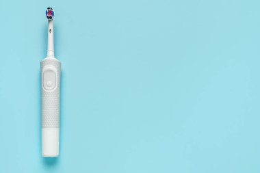 Mavi arka planda modern elektrikli diş fırçası. Dünya Diş Hekimi Günü