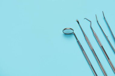 Mavi arka planda bir takım diş aletleri. Dünya Diş Hekimi Günü