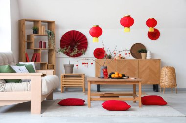 Mandalinalı kahve masası, çay seti ve şenlikli oturma odasında yerde yastıklar. Çin Yeni Yıl Kutlaması