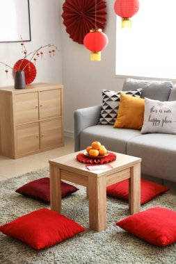 Mandalinalı kahve masası ve şenlikli oturma odasında yerde minderler. Çin Yeni Yıl Kutlaması