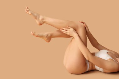 Kahverengi arka planda selülit sorunu olan güzel bir genç kadın.