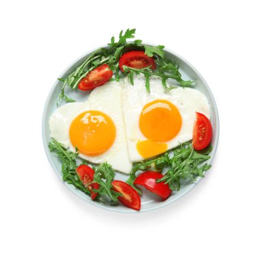 Beyaz arka planda lezzetli yumurta, domates ve roka tabağı.