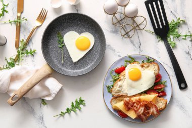 Lezzetli kızarmış yumurta, kruvasan, domates ve roka karışımı.