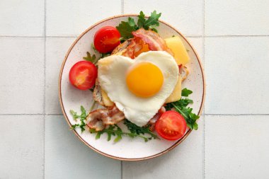 Lezzetli kızarmış yumurta, tost, pastırma, domates ve arkaplanda roka.
