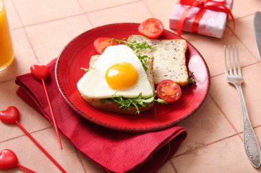 Lezzetli kızarmış yumurta, tost, domates ve bej kaplamalı roka, yakın plan.